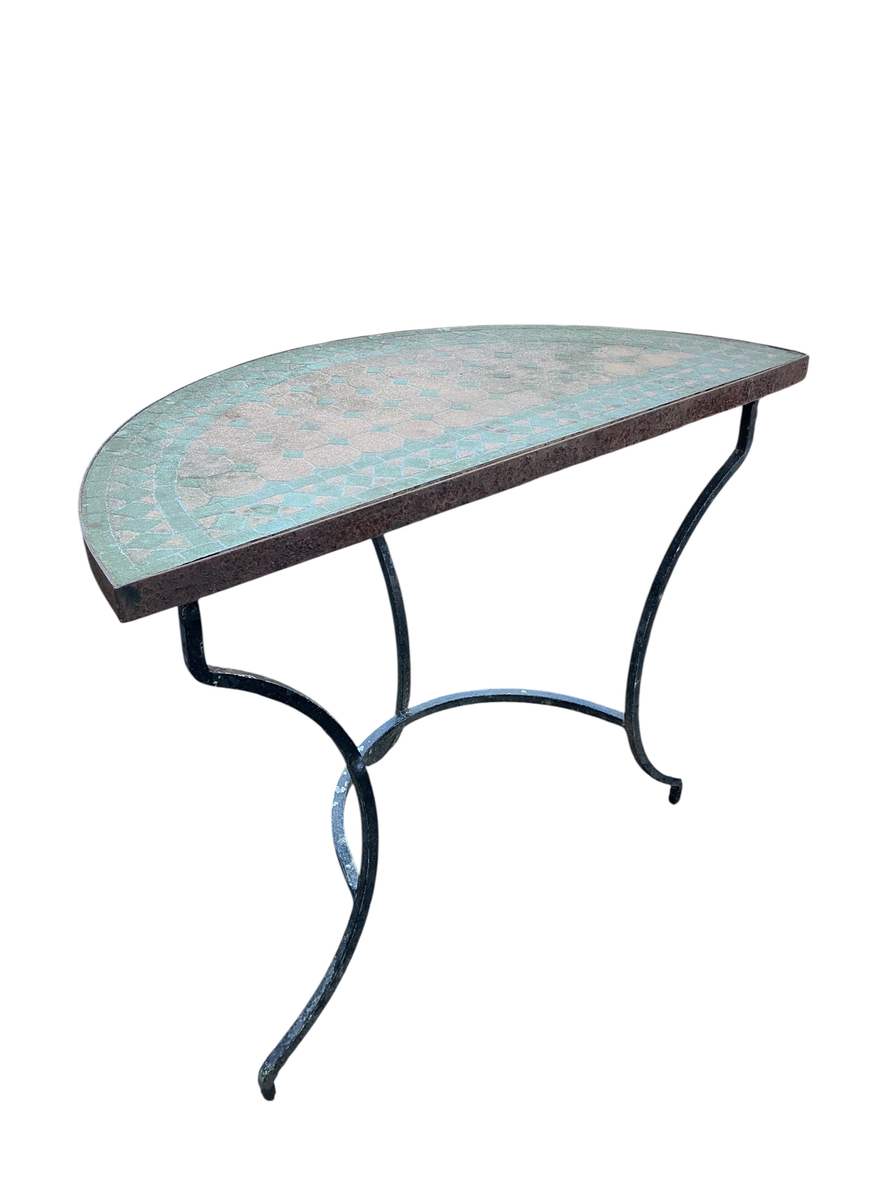 A mosaic topped demi-lune wrought iron garden table, width 96cm and a circular metal folding table with two chairs (requiring new bolts)